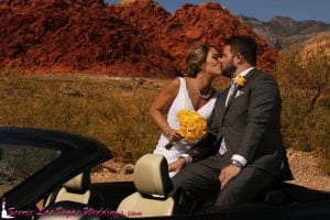 A bride and groom kissing in a car.