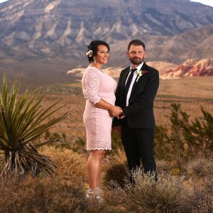 A bride and groom celebrating their special day amidst the breathtaking red rocks of a desert landscape.