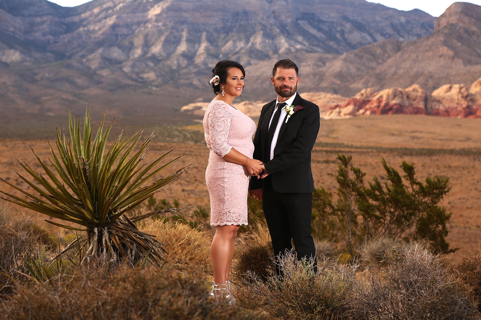 A bride and groom celebrating their special day amidst the breathtaking red rocks of a desert landscape.