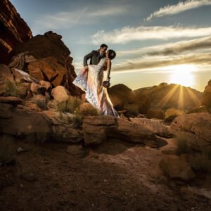 A bride and groom have a scenic wedding kiss in the desert at sunset in Las Vegas.