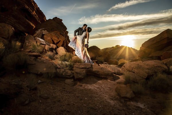 A bride and groom have a scenic wedding kiss in the desert at sunset in Las Vegas.
