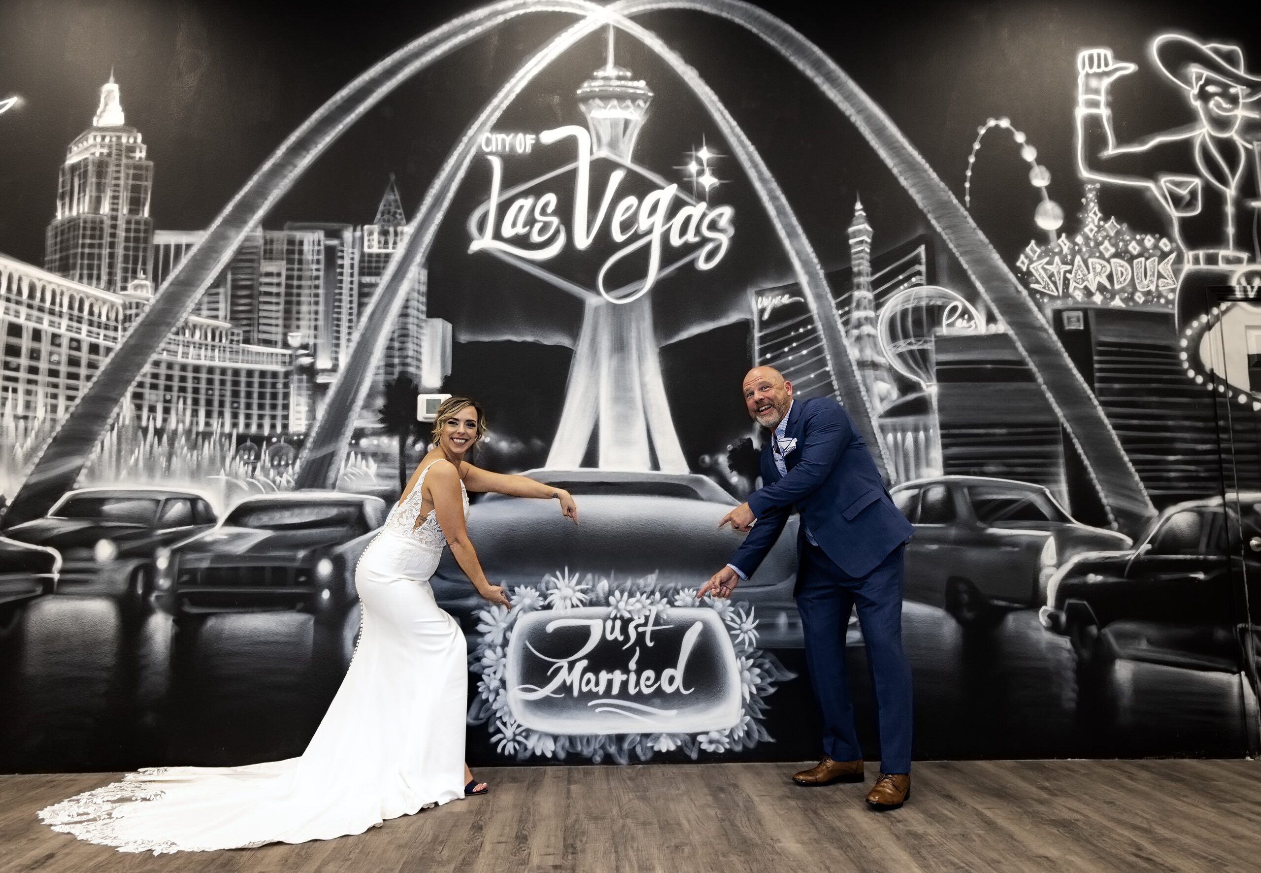 A bride and groom posing in front of a las vegas sign.